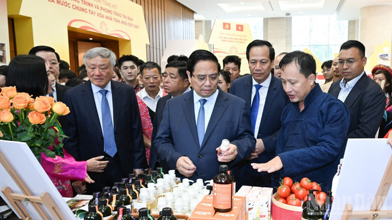 Thủ tướng Phạm Minh Ch&iacute;nh tham quan một gian h&agrave;ng trưng b&agrave;y c&aacute;c sản phẩm ti&ecirc;u biểu. (Ảnh: TRẦN HẢI)