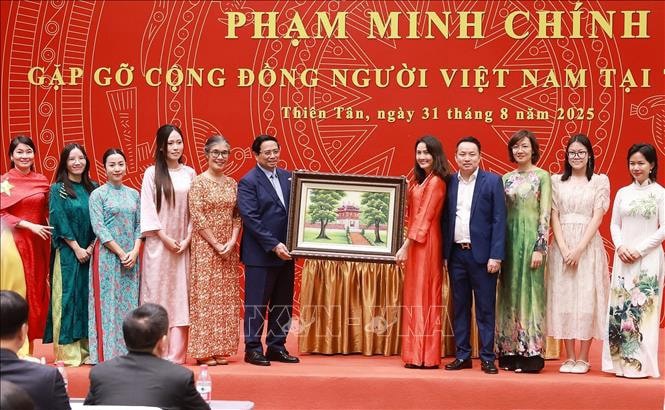 Thủ tướng Phạm Minh Chính tặng quà cộng đồng người Việt Nam tại Trung Quốc. Ảnh: Dương Giang/TTXVN. 