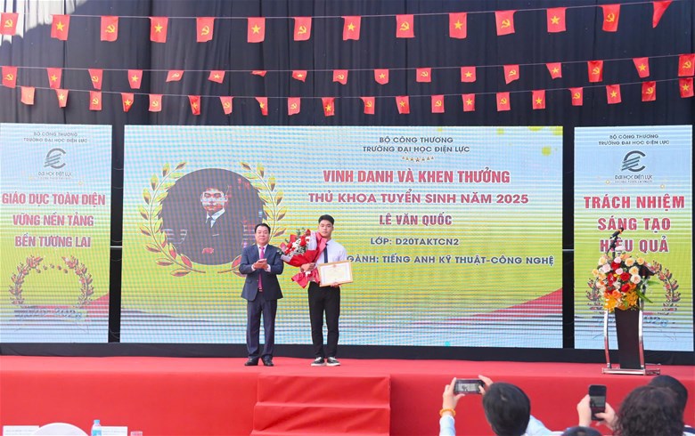 NGƯT.PGS.TS Vũ Đình Ngọ – Bí thư Đảng ủy, Chủ tịch Hội đồng trường tặng hoa và trao bằng khen thủ khoa tuyển sinh đầu vào Lê Văn Quốc - Lớp D20TAKTCN2.