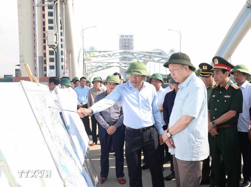 Tổng Bí thư Tô Lâm nghe lãnh đạo tỉnh Thái Nguyên báo cáo về công tác khắc phục hậu quả bão lụt tại cầu Bến Tượng. Ảnh: Thống Nhất/TTXVN 