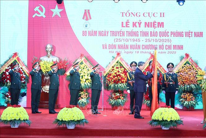 Tổng Bí thư Tô Lâm gắn Huân chương Hồ Chí Minh lên lá cờ truyền thống lực lượng Tình báo Quốc phòng Việt Nam - Ảnh: TTXVN