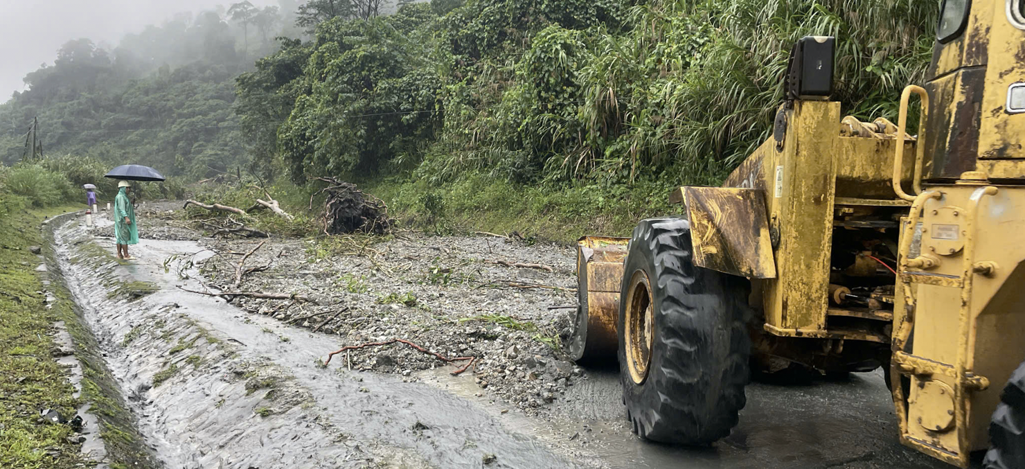 Lực lượng chức năng huy động m&aacute;y m&oacute;c, nh&acirc;n lực h&oacute;t dọn đất, đ&aacute; tr&agrave;n xuống mặt đường tại Km1407+800 đường Hồ Ch&iacute; Minh