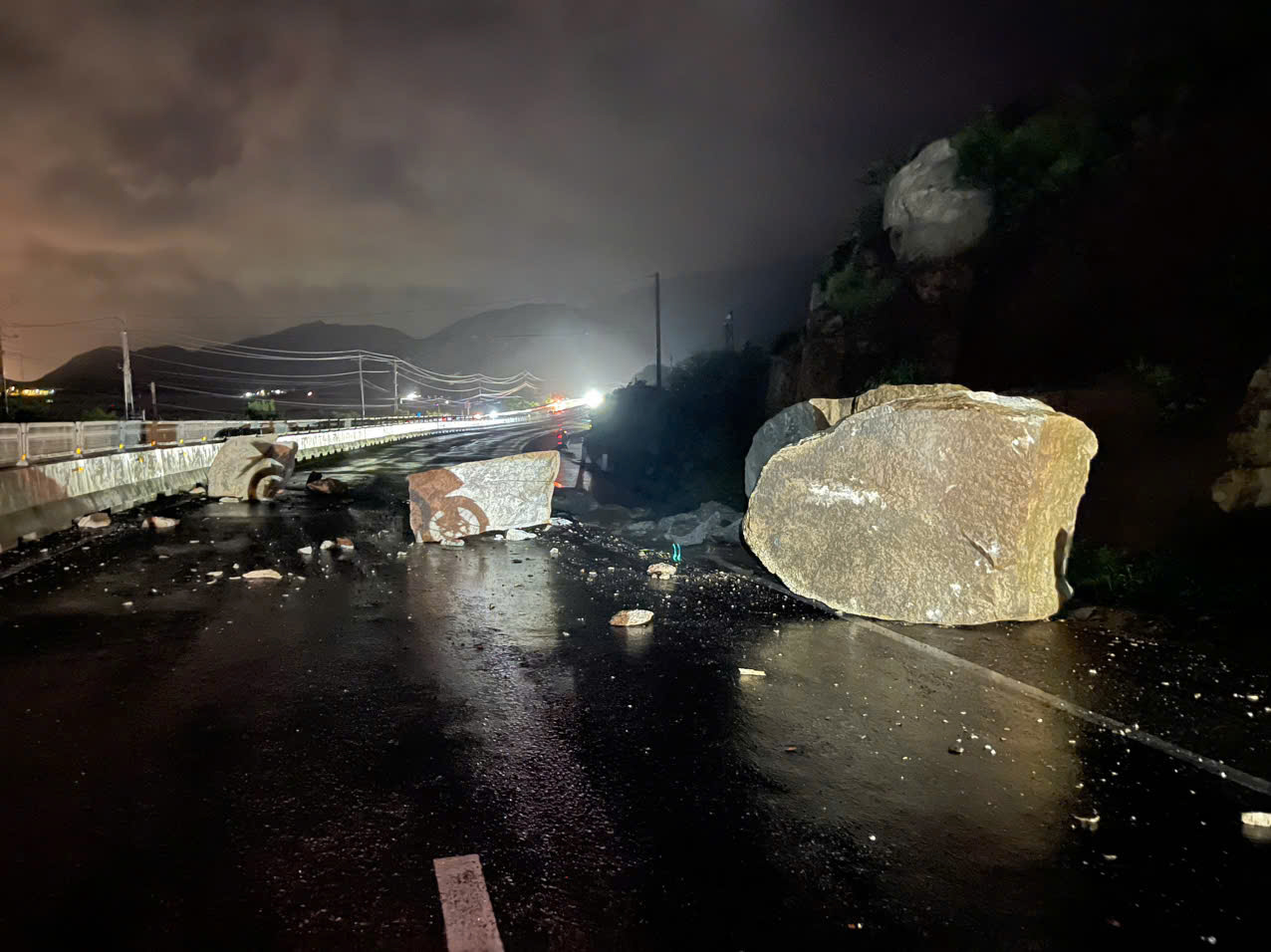 Đất đ&aacute; từ taluy dương rơi xuống mặt đường tại Km1590 tr&ecirc;n Quốc lộ 1 đ&ecirc;m 19/11, c&aacute;c lực lượng triển khai dọn dẹp trong đ&ecirc;m.