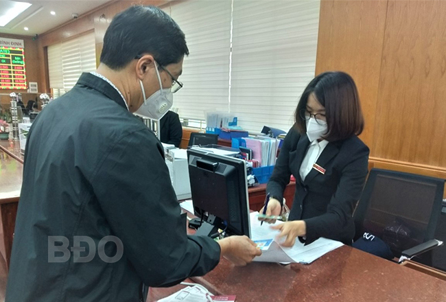 Nhân viên Agribank Bình Định hướng dẫn khách hàng sử dụng thẻ ATM dùng công nghệ chip. Ảnh: Tiến Sỹ