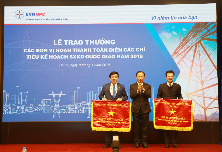 Ông Thiều Kim Quỳnh-Tổng giám đốc Tổng công ty Điện lực miền Bắc (đứng giữa) trao cờ thi đua cho các đơn vị hoàn thành toàn diện các chỉ tiêu kế hoạch năm 2018