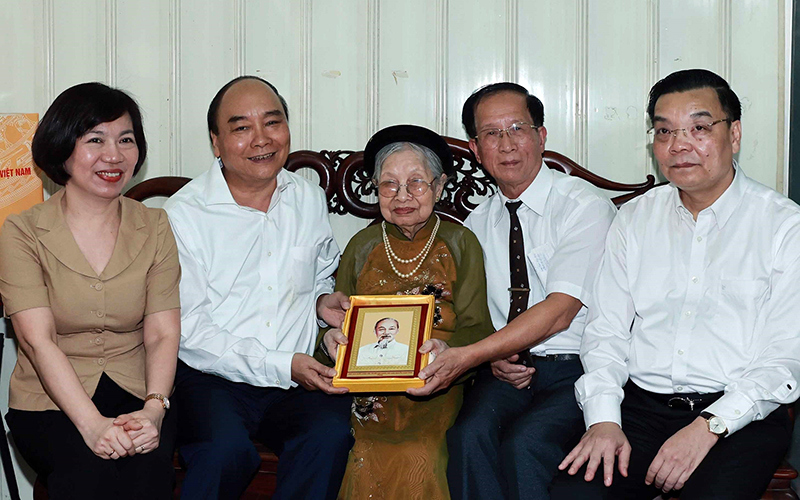 Chủ tịch nước Nguyễn Xuân Phúc (thứ hai từ trái sang) thăm hỏi, tặng quà mẹ liệt sĩ. Ảnh: TTXVN
