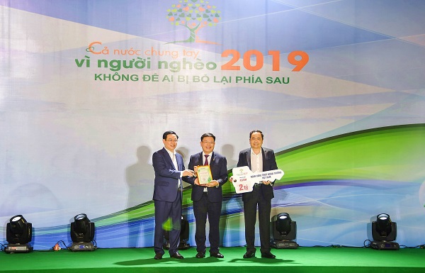 Đồng chí Vương Đình Huệ - Ủy viên Bộ Chính trị, Phó Thủ tướng Chính phủ (ngoài cùng bên phải) trao chứng nhận cảm ơn Vietcombank với những đóng góp cho chương trình “Cả nước chung tay vì người nghèo 2019, không để ai bị bỏ lại phía sau”.