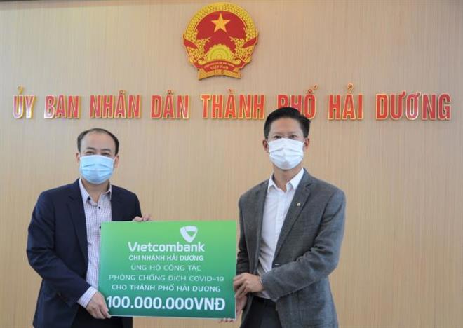 Ông Nguyễn Xuân Cao Cường – Giám đốc Vietcombank Hải Dương (bên phải) trao biển tượng trưng 100 triệu đồng ủng hộ công tác phòng chống dịch Covid-19 trên địa bànTP. Hải Dương