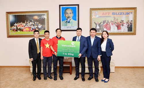 Thay mặt Ban Lãnh đạo Vietcombank, ông Hồng Quang - Ủy viên Hội đồng quản trị kiêm Giám đốc Khối nhân sự (thứ 3 từ phải sang) trao số tiền 1 tỷ đồng của Vietcombank thưởng Đội tuyển Việt Nam cho đại diện Ban huấn luyện đội tuyển