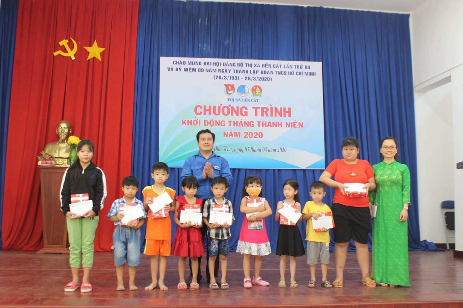 Bà Đặng Thị Thành - Bí thư Đoàn cơ sở  Vietcombank Bắc Bình Dương (ngoài cùng bên phải) và ông Nguyễn Hoàng Vinh - Bí thư Thị đoàn Bến Cát (hàng 2) trao tặng học bổng cho các em học sinh nghèo trên địa bàn.