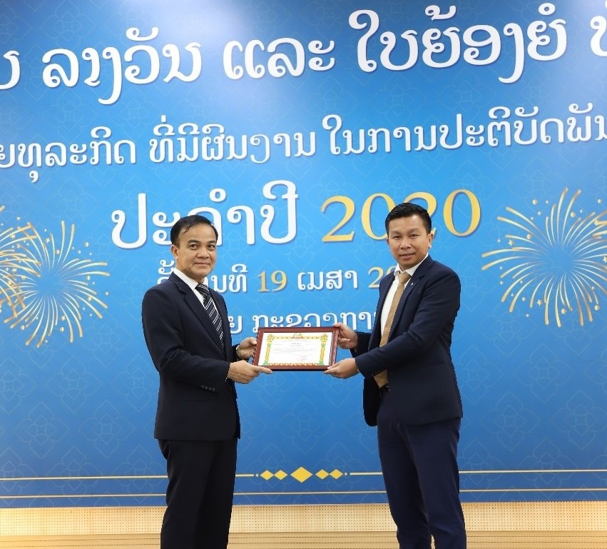 Ông Phouthanouphet XAYSOMBAT - Tổng Cục trưởng Tổng Cục Thuế Lào (bên trái) trao bằng khen cho đại diện Vietcombank Lào
