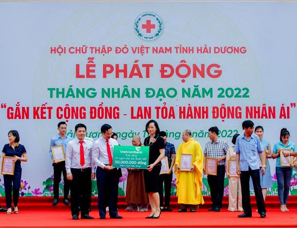 Bà Phạm Minh Đào - Phó Giám đốc Vietcombank Hải Dương, đại diện Công đoàn Chi nhánh trao biển tượng trưng ủng hộ 1 ngôi nhà đại đoàn kết