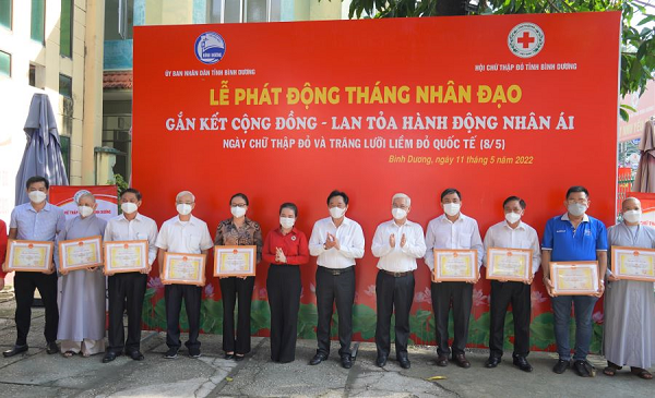 Bà Đặng Thị Hương - Phó Giám đốc Vietcombank Bình Dương (thứ 5 từ trái sang) nhận biểu trưng tri ân tấm lòng vàng của Hội chữ thập đỏ tỉnh Bình Dương
