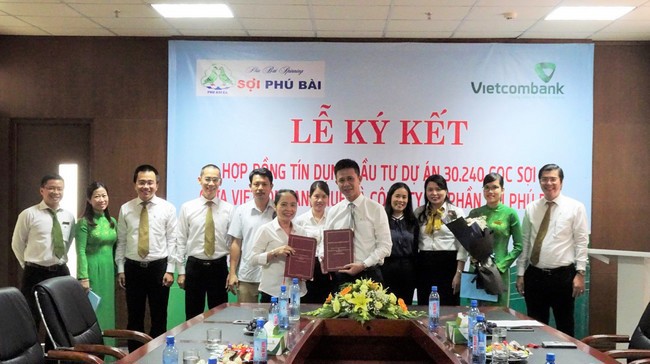 Bà Trần Thị Kim Chi - Tổng Giám đốc Công ty CP sợi Phú Bài (hàng đầu bên trái) và ông Lý Hoàng Vũ –  Giám đốc Vietcombank Huế (hàng đầu bên phải) trao thỏa thuận hợp tác