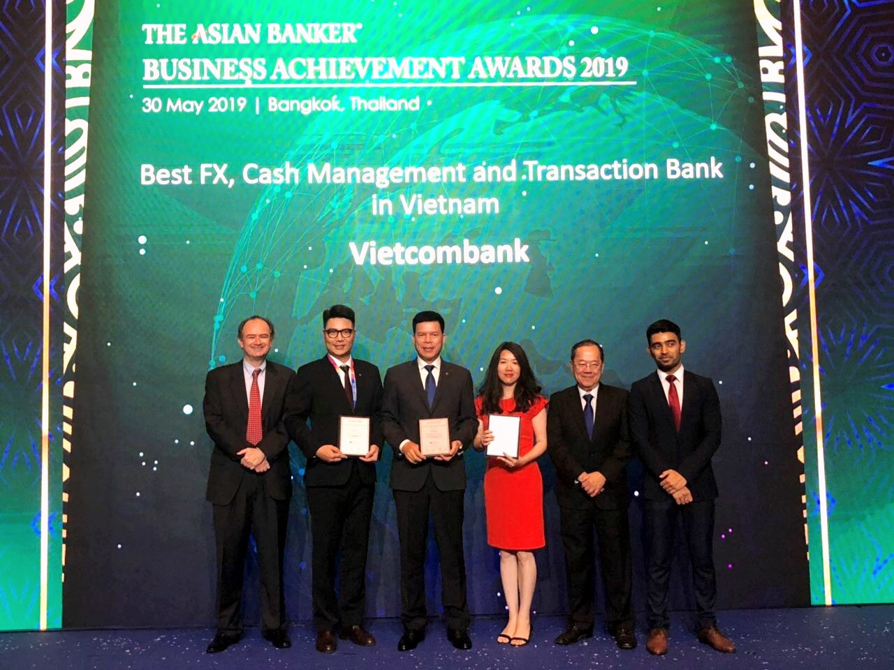 Đại diện Vietcombank, ông Phạm Mạnh Thắng – Phó Tổng Giám đốc (thứ 3 từ trái sang) và bà Phan Khánh Ngọc – Trưởng phòng Quan hệ Công chúng Trụ sở chính (thứ 3 từ phải sang) nhận giải thưởng do The Asian Banker trao tặng
