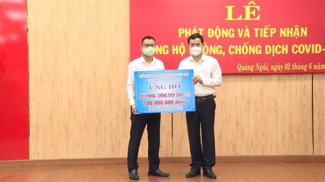 Đại diện Vietcombank Quảng Ngãi, ông Bùi Thanh Hà–Trưởng phòng Khách hàng doanh nghiệp  (bên trái) trao biểu trưng ủng hộ Quỹ phòng chống dịch Covid -19 số tiền 100 triệu đồng
