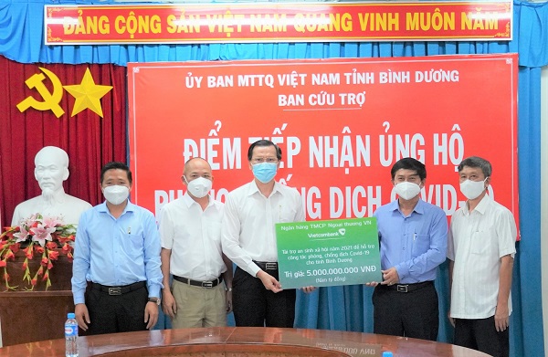 Ông Nguyễn Văn Lộc - Chủ tịch Ủy ban Mặt trận tổ quốc tỉnh Bình Dương (thứ 2 từ phải sang) đại diện lãnh đạo tỉnh Bình Dương tiếp nhận kinh phí ủng hộ phòng chống dịch COVID-19 của Vietcombank