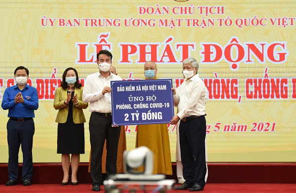 Tổng Giám đốc BHXH Việt Nam Nguyễn Thế Mạnh (bên trái) thay mặt toàn thể công chức, viên chức, người lao động ngành BHXH Việt Nam trao 2 tỷ đồng ủng hộ công tác phòng, chống dịch Covid-19.