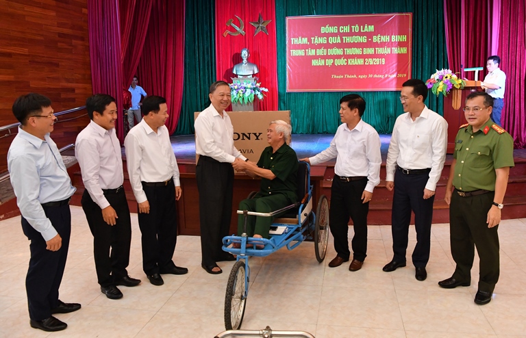 Đại tướng Tô Lâm (thứ 4 từ trái sang) cùng Tổng Giám đốc Vietcombank Phạm Quang Dũng (thứ 2 từ phải sang) thăm hỏi và tặng quà đại diện các thương binh tại Trung tâm điều dưỡng thương binh Thuận Thành (Bắc Ninh) 