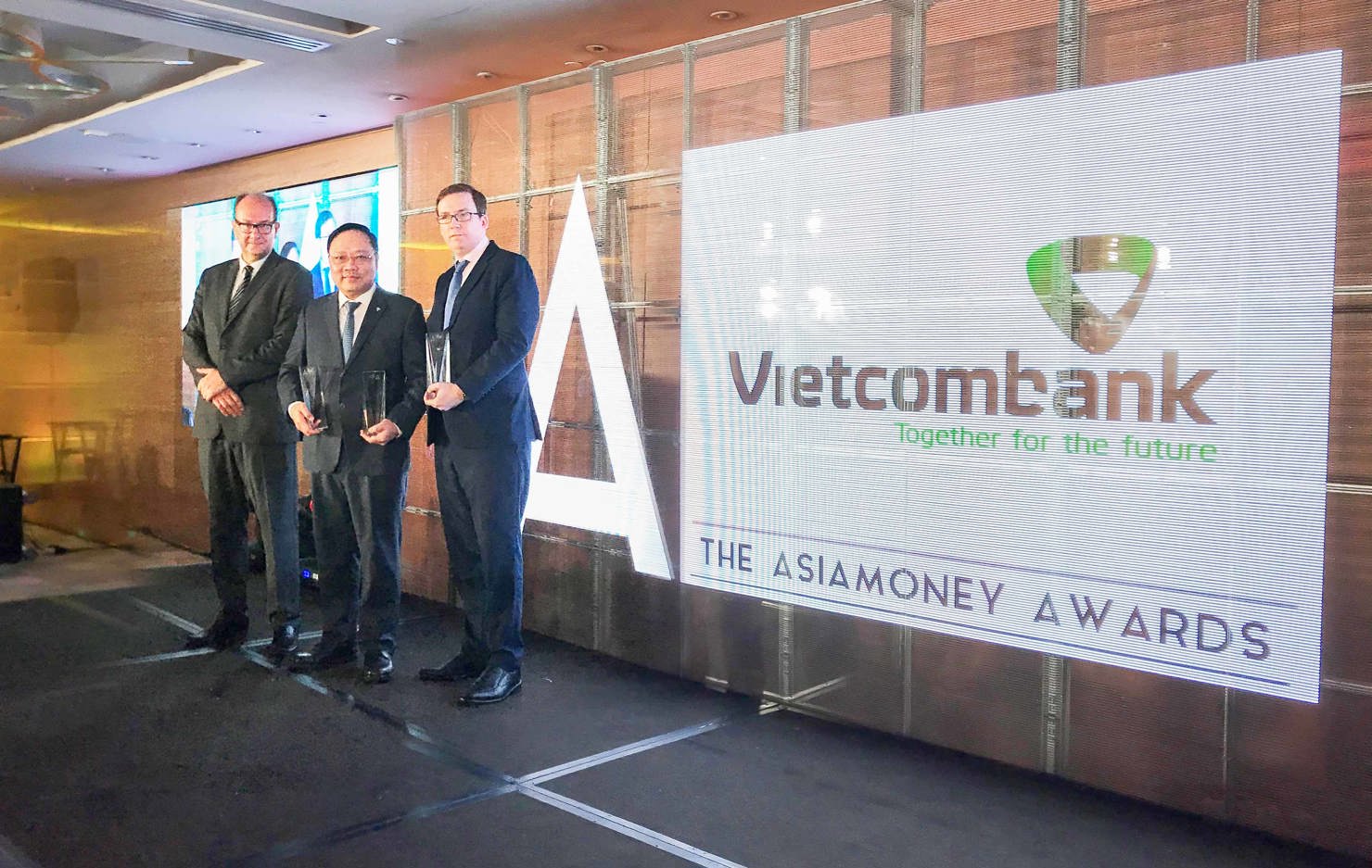 Đại diện Vietcombank, ông Phạm Anh Tuấn – Ủy viên HĐQT (đứng giữa) nhận giải thưởng của Tạp chí Asiamoney