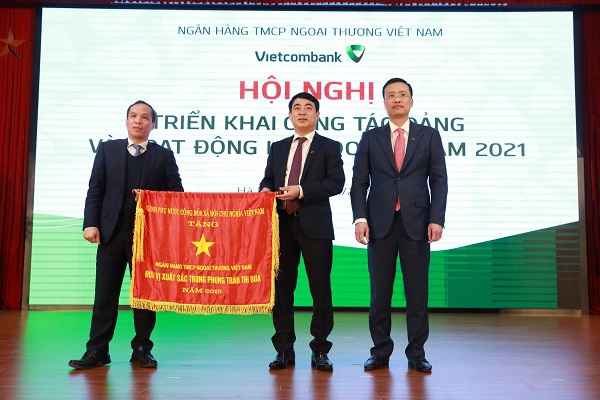 Thừa ủy quyền của Thủ tướng Chính phủ, ông Đoàn Thái Sơn – Phó Thống đốc NHNN Việt Nam (ngoài cùng, bên trái) trao Cờ thi đua của Chính phủ cho tập thể Vietcombank