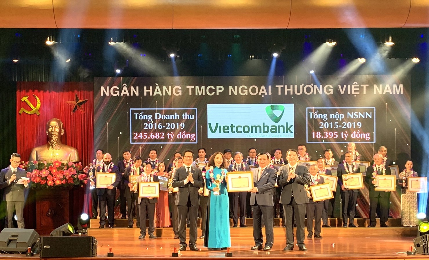 Bộ trưởng Bộ Tài chính Đinh Tiến Dũng trao tặng Bằng khen cho bà Nguyễn Thị Kim Oanh – Phó Tổng Giám đốc Vietcombank, đại diện Vietcombank lên sân khấu nhận vinh danh