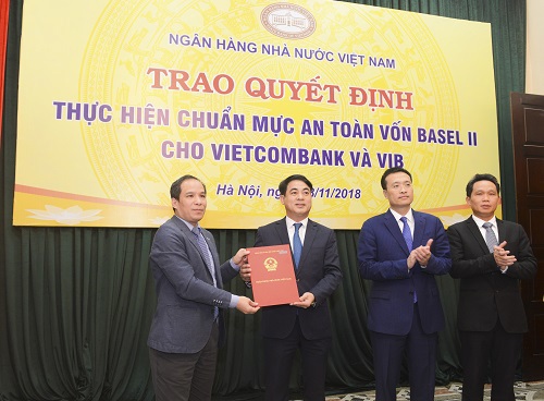 Ông Đoàn Thái Sơn – Phó Thống đốc NHNN (ngoài cùng bên trái) trao quyết định công nhận Vietcombank thực hiện chuẩn mực an toàn vốn Basel II 