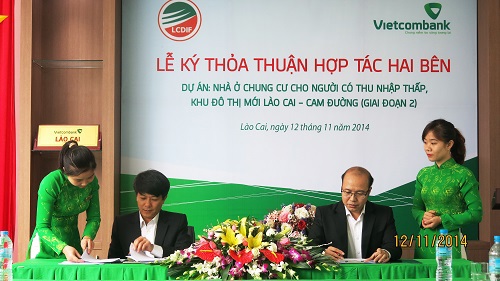 Ông Đặng Việt Hùng - Giám đốc Vietcombank Lào Cai (hàng đầu, bên phải) và ông Nguyễn Văn Minh - Giám đốc Quỹ Đầu tư Phát triển tỉnh Lào Cai đại diện cho 2 bên ký kết thỏa thuận hợp tác