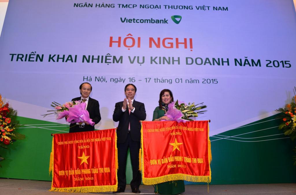 Thống đốc NHNN Nguyễn Văn Bình (giữa) thừa ủy quyền của Thủ tưởng Chính phủ, trao Cờ thi đua cho đại diện Chi nhánh Vietcombank TP.HCM và Chi nhánh Vietcombank Gia Lai đã hoàn thành xuất sắc, toàn diện nhiệm vụ, dẫn đầu phong trào thi đua 