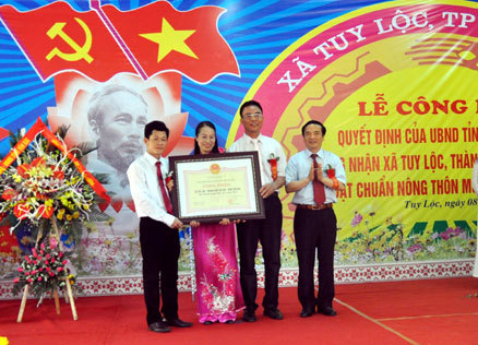 Đồng chí Hoàng Xuân Nguyên - Phó chủ tịch UBND Tỉnh(ngoài cùng, bên phải) trao Quyết định công nhận đạt chuẩn nông thôn mới cho xã Tuy Lộc. 