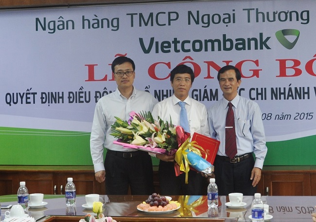 Ông Phạm Quang Dũng - Tổng giám đốc Vietcombank (ngoài cùng bên trái) và ông Nguyễn Văn Cư - Giám đốc Chi nhánh NHNN tỉnh Gia Lai (ngoài cùng bên phải) trao quyết định và tặng hoa chúc mừng ông Trương Anh Tuấn - tân Giám đốc Vietcombank Gia Lai