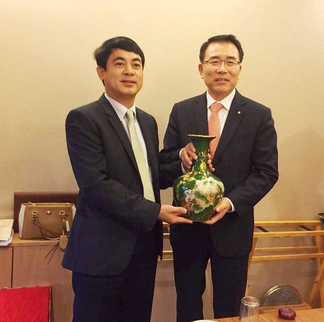 Chủ tịch HĐQT Vietcombank Nghiêm Xuân Thành (bên trái) tặng quà lưu niệm cho Tổng giám đốc Ngân hàng Shinhan