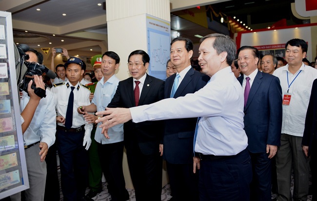 Phó Thống đốc NHNN Đào Minh Tú (hàng đầu, ngoài cùng bên phải) tiếp đón Thủ tướng Chính phủ Nguyễn Tấn Dũng và lãnh đạo cấp cao các Bộ/Ngành thăm gian triển lãm thành tựu ngành Ngân hàng