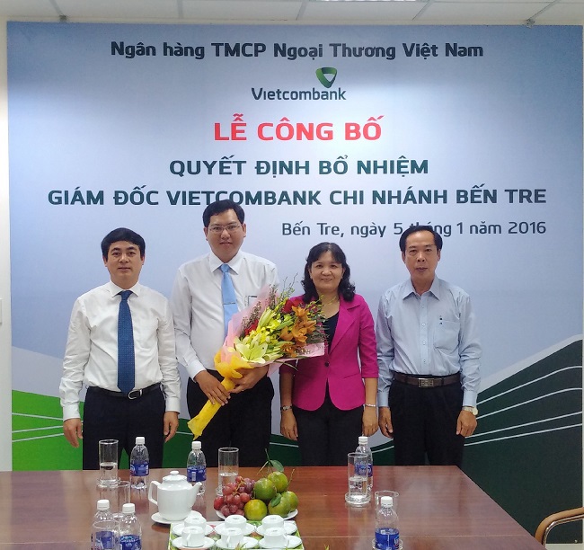  Ông Nghiêm Xuân Thành - Chủ tịch HĐQT Vietcombank (ngoài cùng bên trái) trao quyết định và tặng hoa cho tân Giám đốc Vietcombank Bến Tre