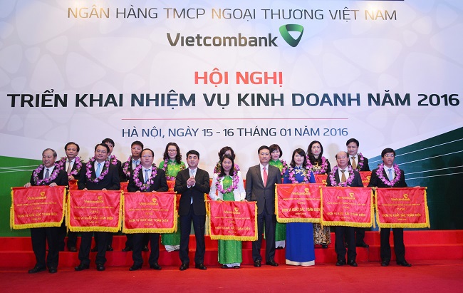 Ông Nghiêm Xuân Thành - Chủ tịch HĐQT (hàng đầu, thứ 4 từ trái sang) và ông Phạm Quang Dũng - Tổng giám đốc (thứ 4 từ phải sang) tặng danh hiệu Đơn vị xuất sắc toàn diện năm 2015 cho 15 chi nhánh Vietcombank