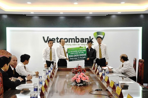 Ông Trần Văn Tiết – Phó Giám đốc Vietcombank Gia Lai (thứ 2 từ trái sang) trao trả quyền lợi bảo hiểm cho ông Lê Hợp (con trai khách hàng) 