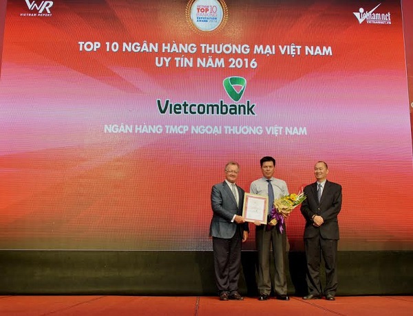 Đại diện Vietcombank, ông Phạm Mạnh Thắng - Phó Tổng giám đốc (đứng giữa) nhận giải thưởng Top 10 ngân hàng uy tín tại Việt Nam năm 2016 do Ban tổ chức trao tặng 