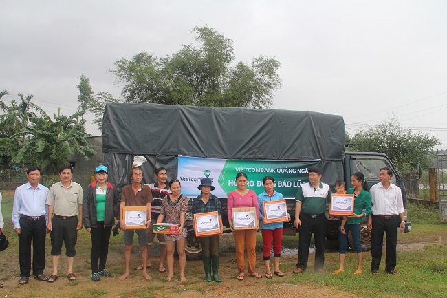 Bà Phạm Thị Thúy Kiều – Giám đốc Vietcombank Quảng Ngãi (thứ 3 từ trái sang) trao tặng quà cho đồng bào huyện Mộ Đức bị lũ lụt