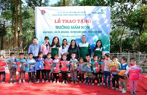 Niềm vui của các cháu học sinh khi nhận quà tặng của thành viên Đoàn Vietcombank dưới sự chứng kiến của lãnh đạo Phòng Giáo dục và Đào tạo cùng lãnh đạo nhà trường