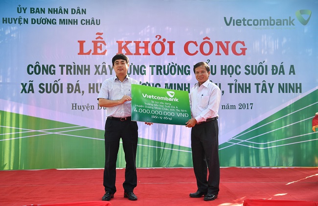 Chủ tịch HĐQT Vietcombank Nghiêm Xuân Thành trao biển tượng trưng số tiền tài trợ 4 tỷ đồng cho lãnh đạo địa phương