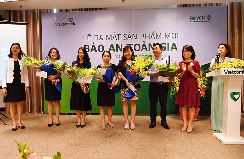 Bà Đoàn Hồng Nhung (thứ 2 từ phải sang) và bà Young Lai Yin (ngoài cùng bên trái) tặng hoa chúc mừng các khách hàng tham gia sản phẩm Bảo An Toàn Gia