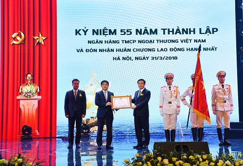 Đồng chí Vương Đình Huệ - Ủy viên Bộ Chính trị, Phó Thủ tướng Chính phủ (thứ 3 từ trái sang) thừa ủy quyền của Chủ tịch nước trao Huân chương Lao động hạng Nhất cho Vietcombank