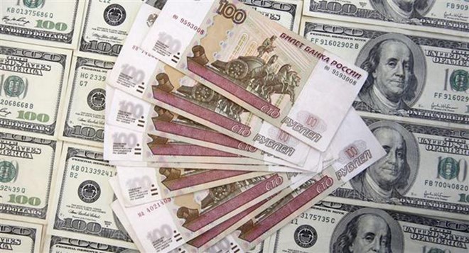 Đồng Ruble của Nga (phía trên) và đồng USD. (Ảnh: Reuters/TTXVN)