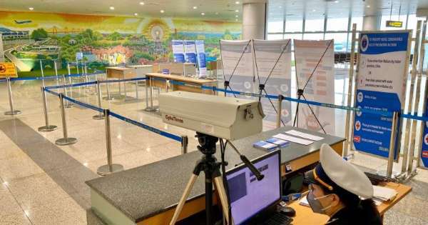 Nhân viên ngồi trước máy đo thân nhiệt bịt kín khẩu trang tại khu kiểm soát, cách ly phòng chống virus corona tại sân bay Nội Bài.