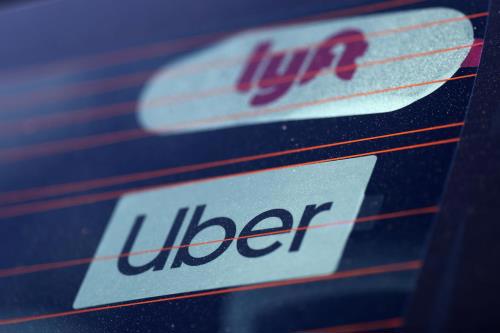Logo của Uber và Lyft trên xe ô tô ở Mỹ. Ảnh: Reuters