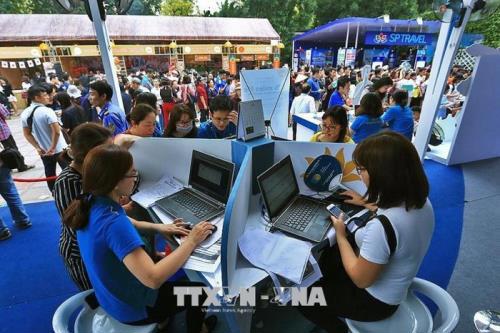 Khách hàng mua vé du lịch trực tuyến tại Hội chợ Du lịch Quốc tế Việt Nam - VITM Hà Nội 2018.