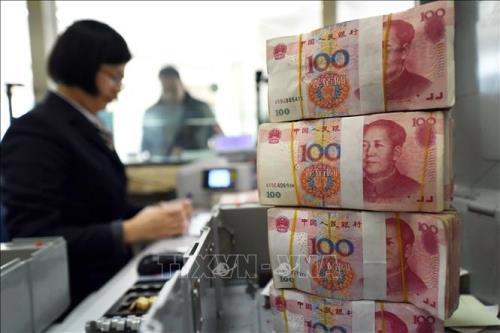 Kiểm đồng 100 Nhân dân tệ tại ngân hàng ở tỉnh Giang Tô. Ảnh: AFP/TTXVN