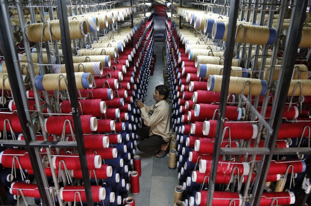 Công nhân kiểm tra các ống sợi trên máy dệt thảm tại một nhà máy ở ngoại ô Jammu, Ấn Độ. (Ảnh: AFP/TTXVN)