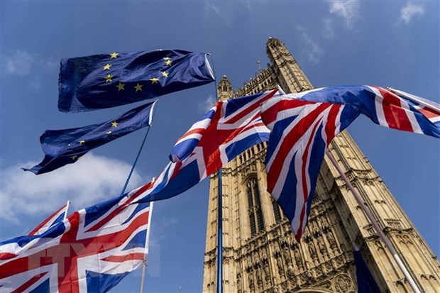 Quốc kỳ Anh (dưới) và cờ Liên minh châu Âu (EU) bên ngoài tòa nhà Quốc hội Anh ở Westminster, London. (Ảnh: AFP/TTXVN)