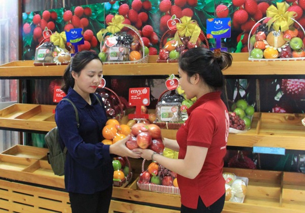 Người tiêu dùng mua trái cây tại cửa hàng được gắn biển nhận diện